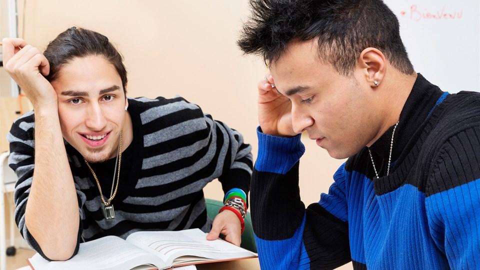 Två killar pluggar i ett klassrum